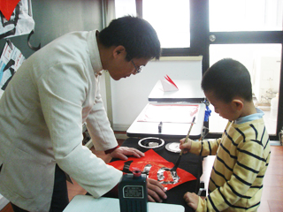 老師在指導(dǎo)小朋友寫書法