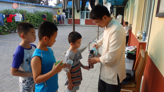 
生活老師為小學員添水，給予悉心照顧和安全教育