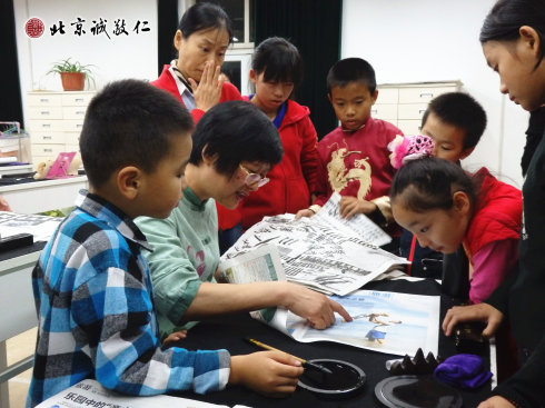 配圖：楊老師指導小學員書法要領 彩色較多的報紙不宜用來書寫